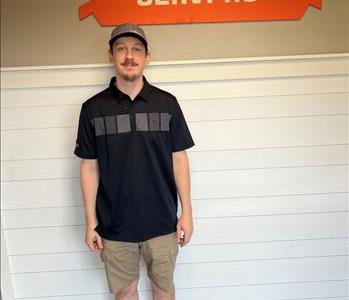 A young man standing in front of the SERVPRO of St. Cloud trailer. 