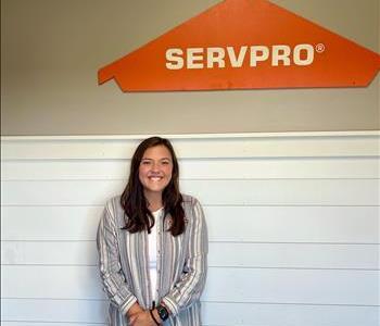 Young lady standing in front of the SERVPRO of St. Cloud trailer.