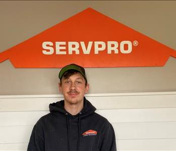 A young man standing in front of the SERVPRO of St. Cloud trailer. 