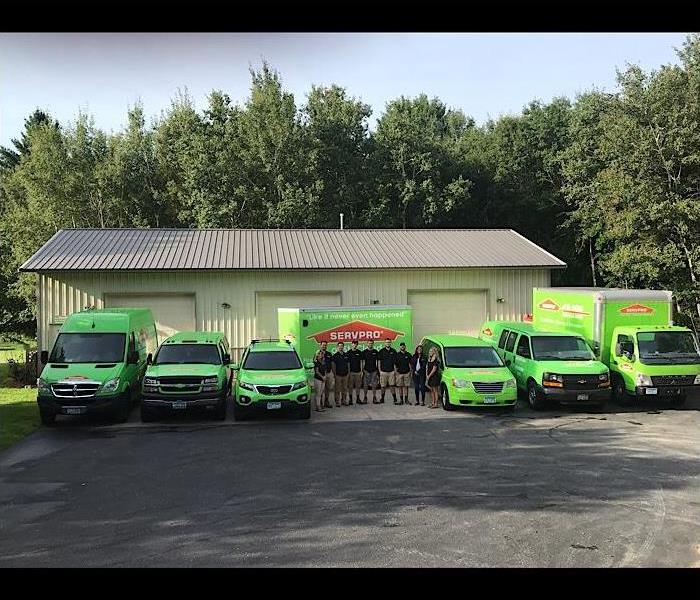 Group photo of the team at SERVPRO of St. Cloud standing in front of all the green vehicles.