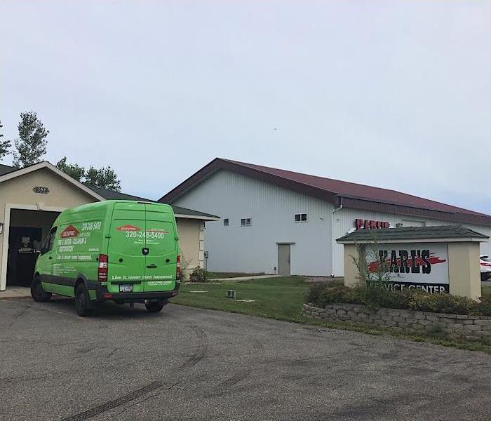 Green SERVPRO vehicle in front of commercial building.